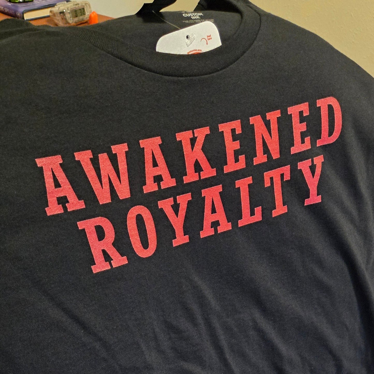 Black t-shirt with 'Awakened Royalty' text.